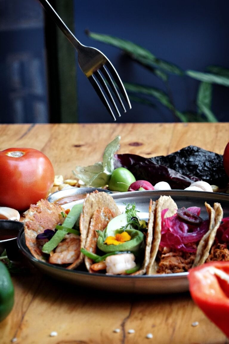 Assorted tacos garnished with fresh toppings on a plate with lime, ready for taco night